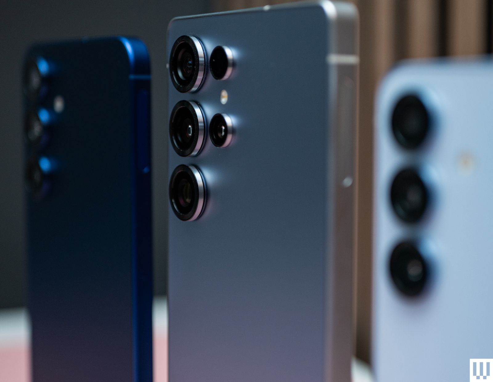 Rear view of three smartphones  showing the camera lenses of each